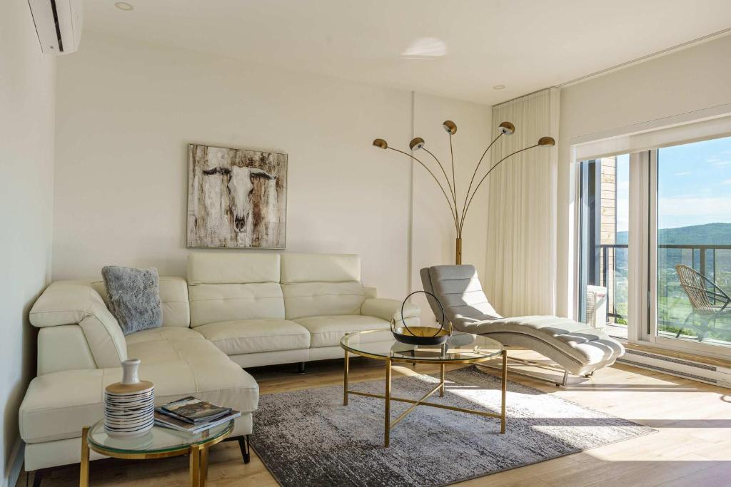 a living room with a couch and a table at 304 - Chic Minimalist Condo - River & Serenity in Baie-Saint-Paul