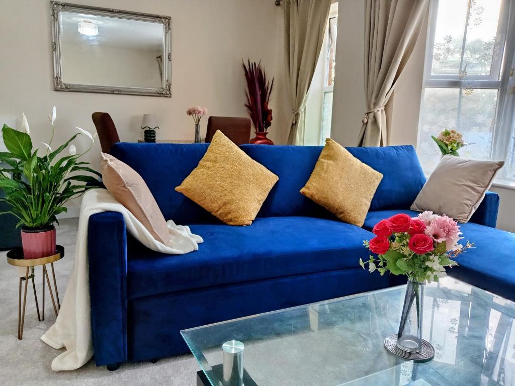 a blue couch in a living room with a glass table at 2 Bedrooms Flat in Surrey, 30 min to London in Woking