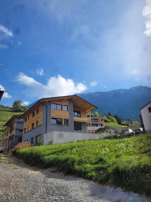 a building on a hill with mountains in the background at Panoramablick Kaunergrat Homes in Kaunerberg