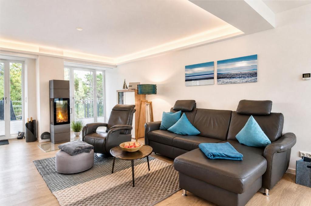 a living room with a leather couch and a tv at Ferienwohnung Aquamarin im Haus Arkona Prora in Binz