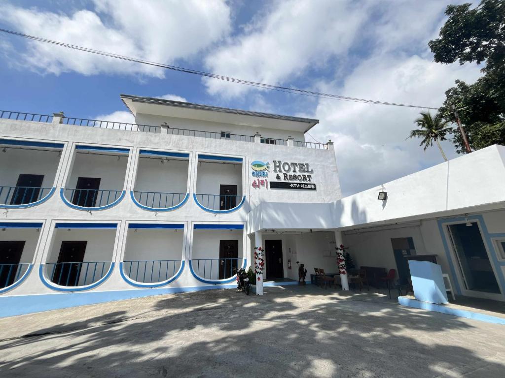 a white building with a sign on the front of it at Shiri Hotel in Silang
