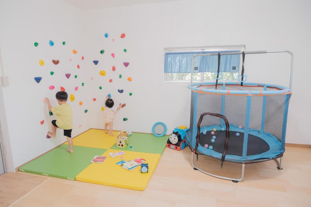 two children playing in a play room with a wall at ふんわり in Miyakojima
