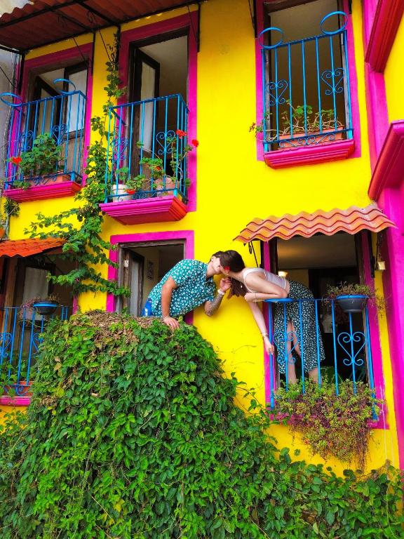 two people are standing outside of a yellow building at Posada "Jardin Huasteca Xilitla" in Xilitla
