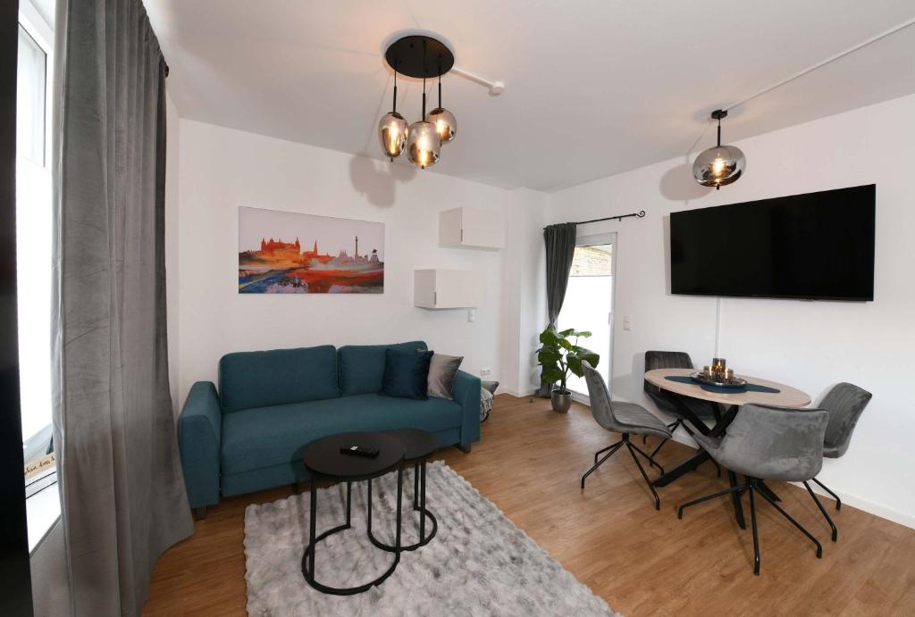 a living room with a blue couch and a table at Apartment Schweriner Lieblingsplatz in Schwerin