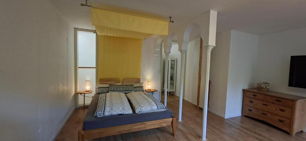ein Schlafzimmer mit Himmelbett und Kommode in der Unterkunft Downstairs6b WIEDERERÖFFNUNG IM JULI ! in Dipperz