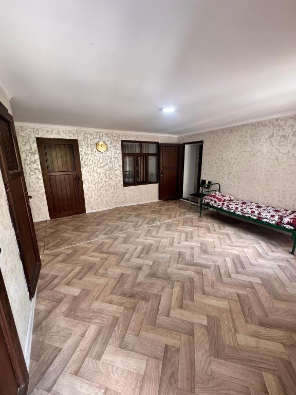 an empty room with a wooden floor in a building at Sharshara-Darvoz in Sangovy