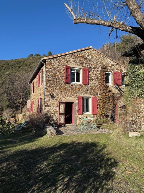 an old stone house with red shutters on it at La Bellevue in Valleraugue
