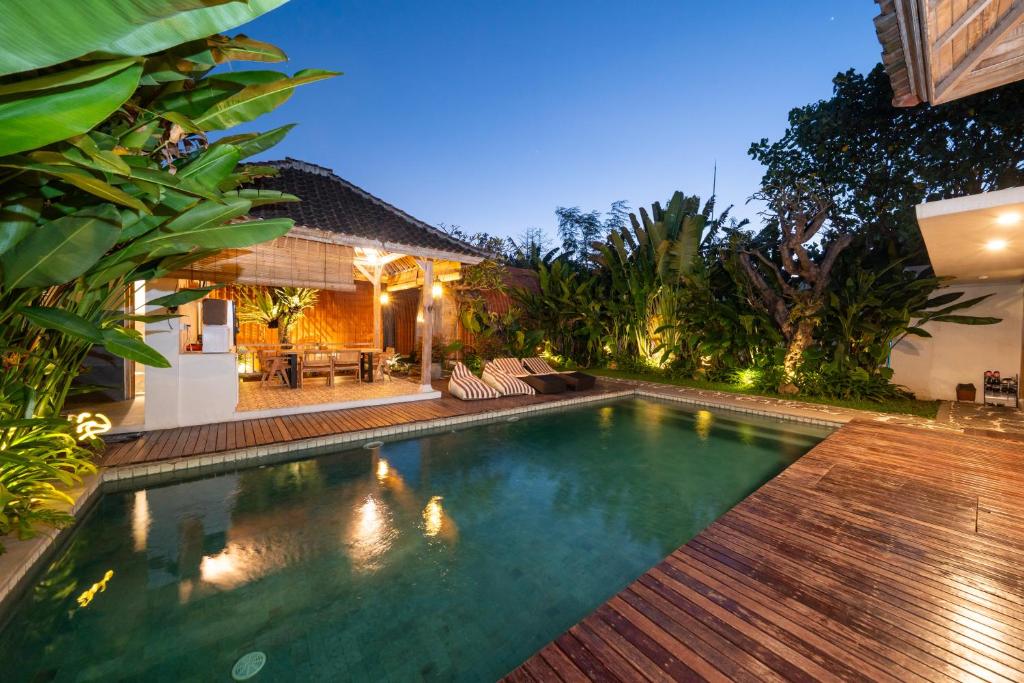a swimming pool in a backyard at night at Omaneil Villa in Uluwatu