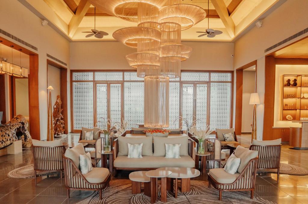 a lobby with chairs and tables and a chandelier at Arth Resorts I Convention I Wellness in Moinabad