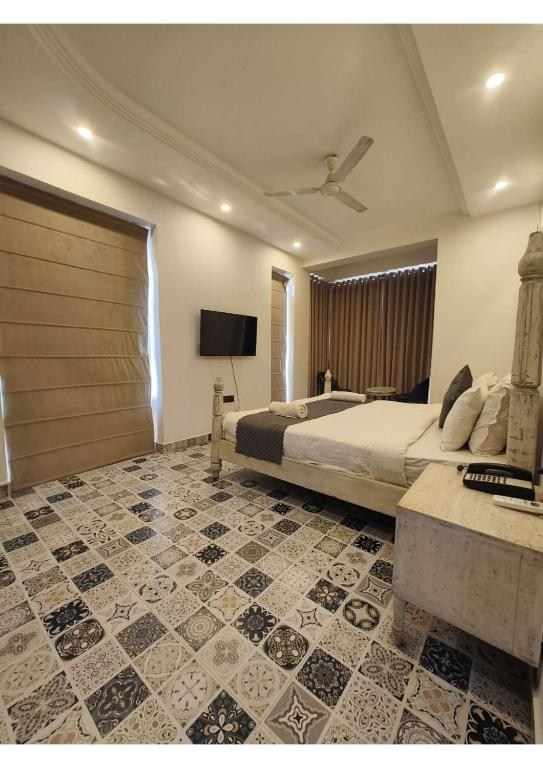 a bedroom with a bed and a tv and a floor at Goa Courtyard in Arpora