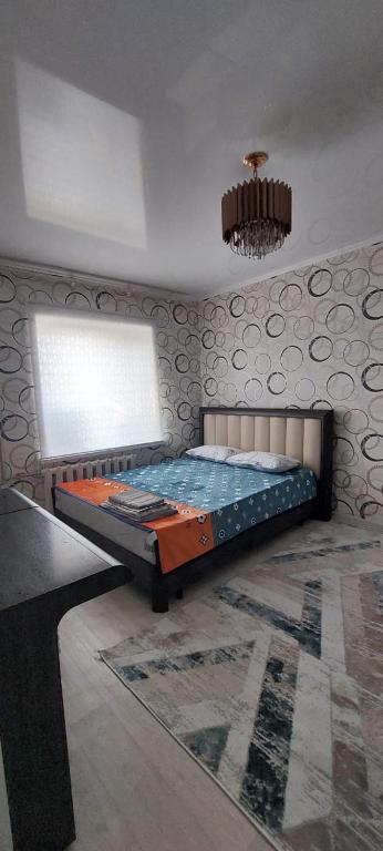 a bedroom with a bed in the corner of a room at Толе би 141А in Qyzylorda