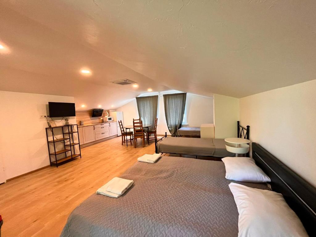 a bedroom with a large bed and a kitchen at Pakalnės sodyba in Skverbai