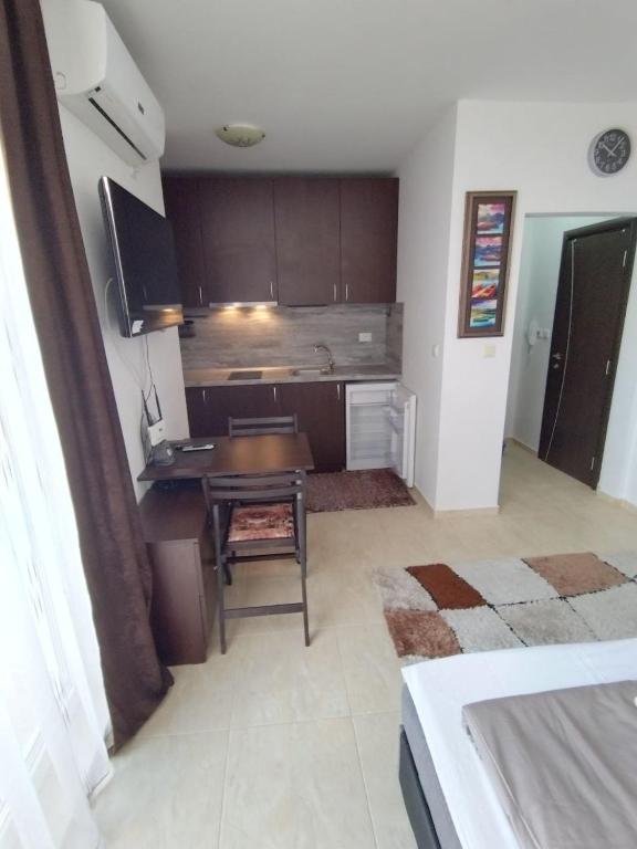 a kitchen with a desk and a table in a room at Comfy Home in Pomorie