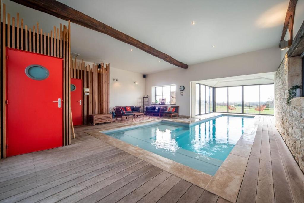 a swimming pool in a house with a red door at Les Grandes Vagastines in Saint-Germain-du-Plain