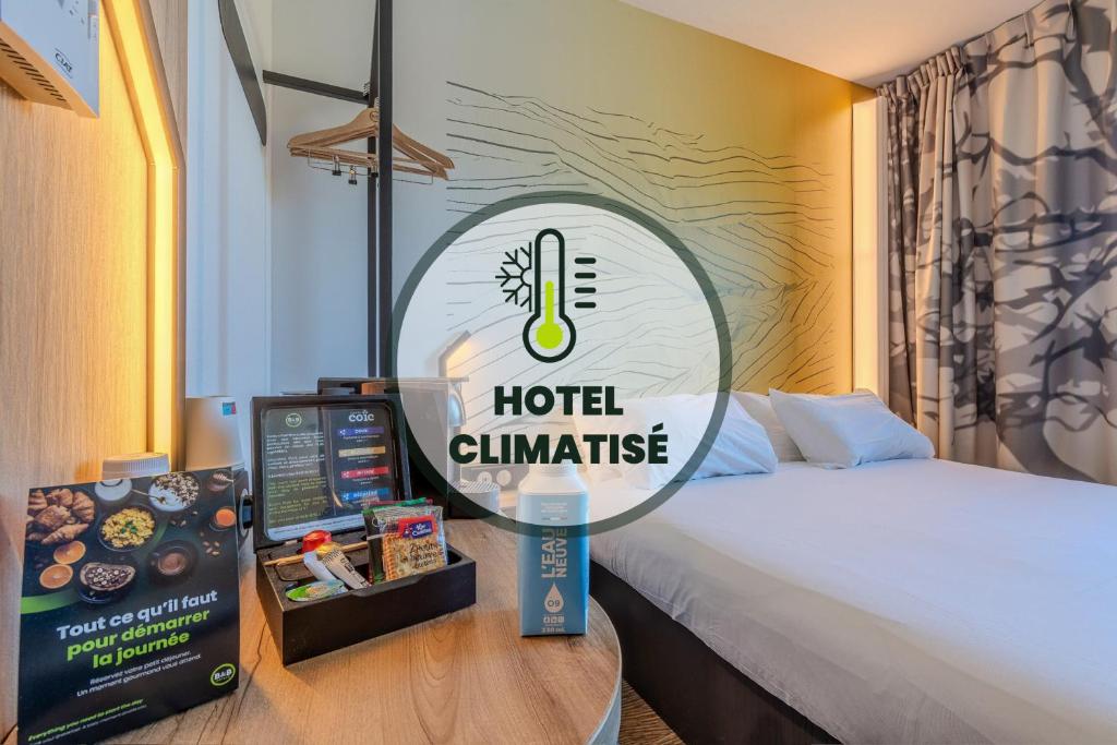 a hotel challenge sign next to a bed and a table at B&B HOTEL Landerneau Bois Noir in Landerneau