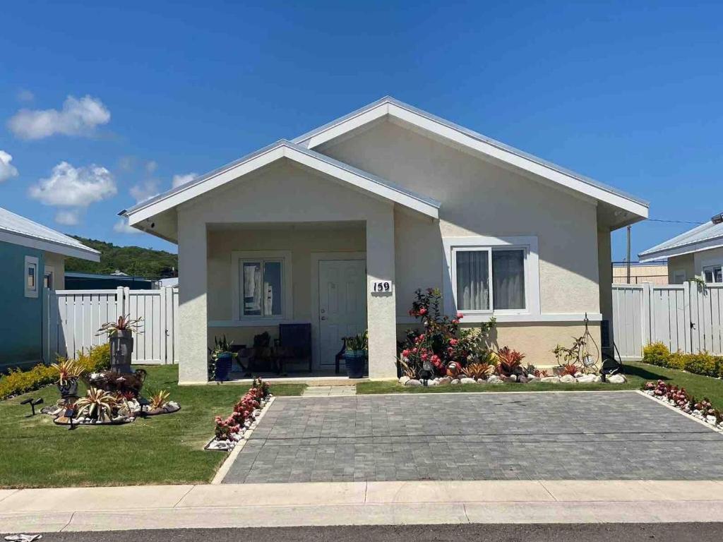 a small house with a white fence at Oceanpointe Serenity Get Away-solar pool WiFi in Lucea
