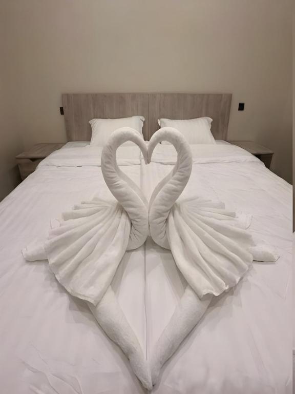 two swans making a heart on a bed at Hail View شقق فيو حائل المخدومة in Hail