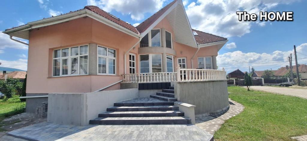 a house with stairs in the front of it at The HOME in Ditrău