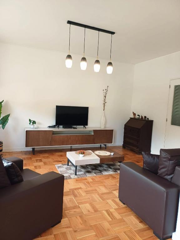 a living room with a couch and a tv at Pinhão House in Pinhão