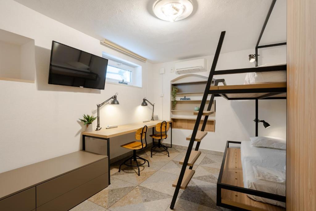 a bedroom with a bunk bed and a desk and a bunk bed at Casa Riccobon in Koper