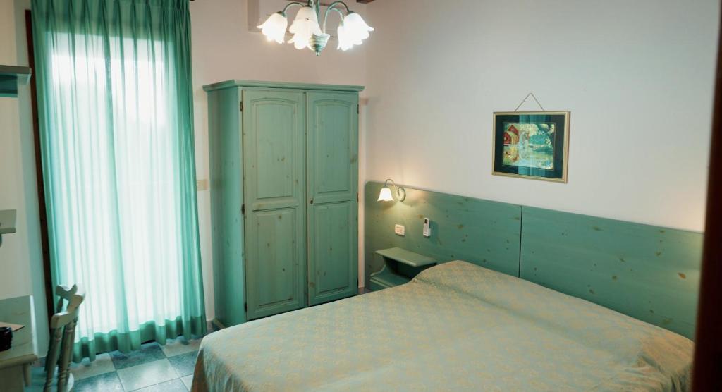 a bedroom with a green cabinet and a bed at Posada di Portixeddu in Portixeddu