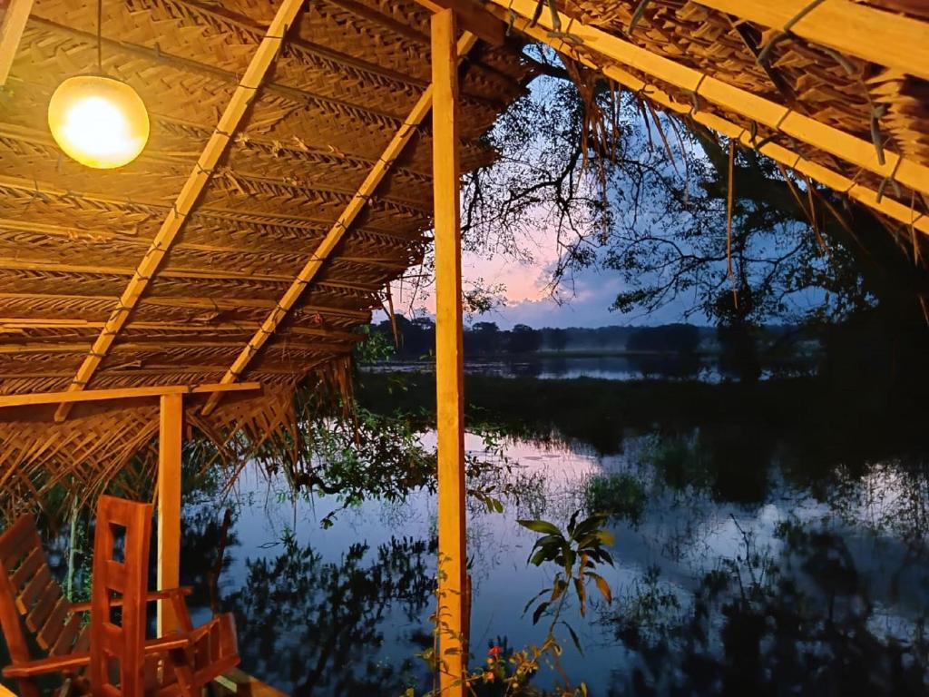 a view from the inside of a house with a pond at Lake View Eco Lodge in Dambulla