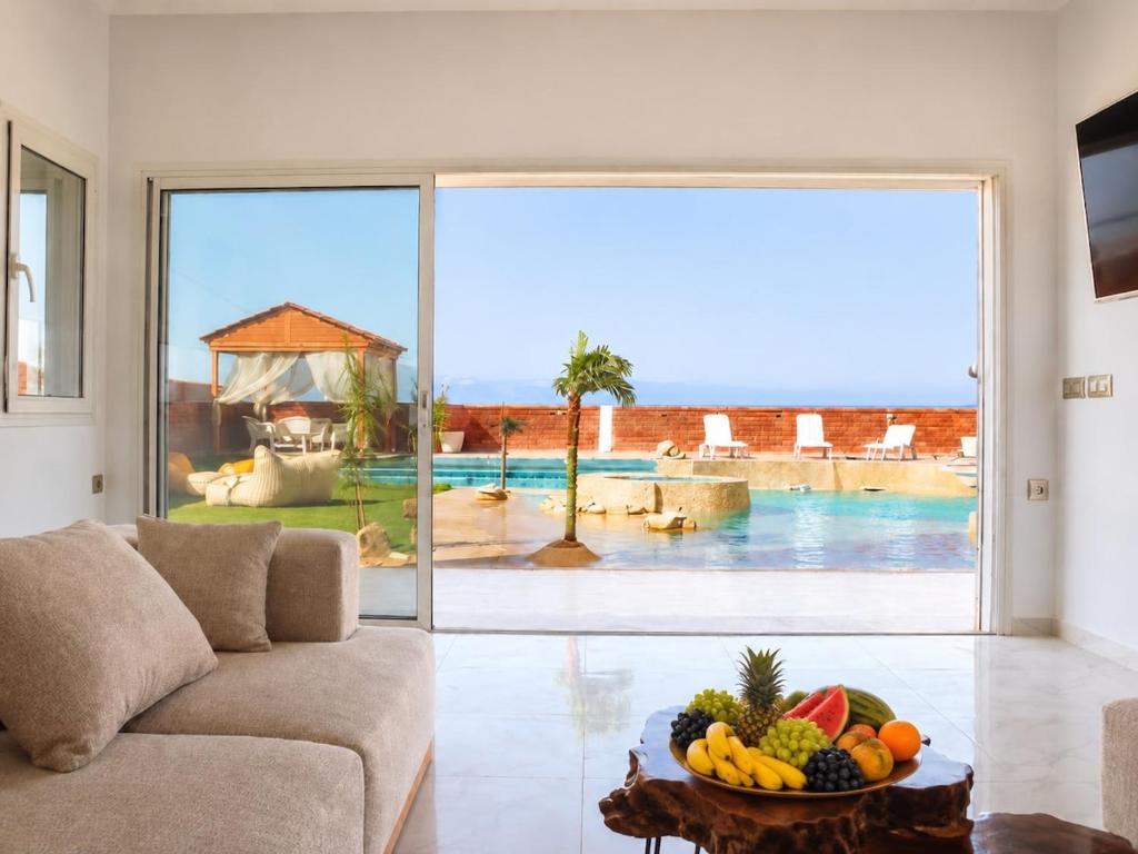 a living room with a couch and a bowl of fruit at Luxury Beachfront Villa with Pool and Jacuzzi in Hennchir Ksar Rhaleb