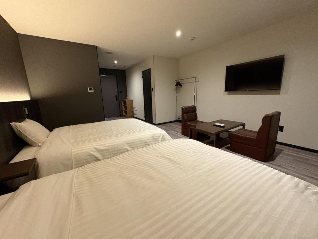 a hotel room with a large bed and a desk at ホテルいづみや in Aizuwakamatsu