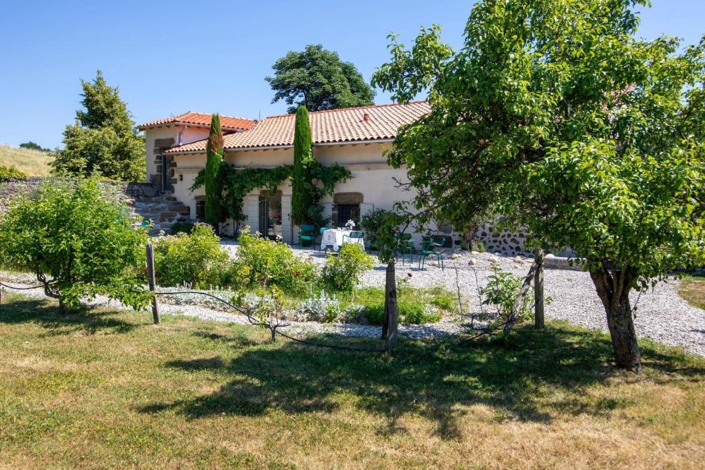 a house in a field with trees in front of it at Les Petits Princes, expérience unique à Polignac in Polignac
