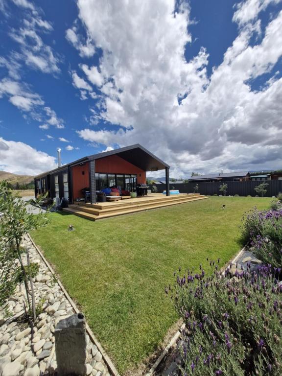 a house with a large lawn in front of it at Modern Omarama Getaway in Omarama