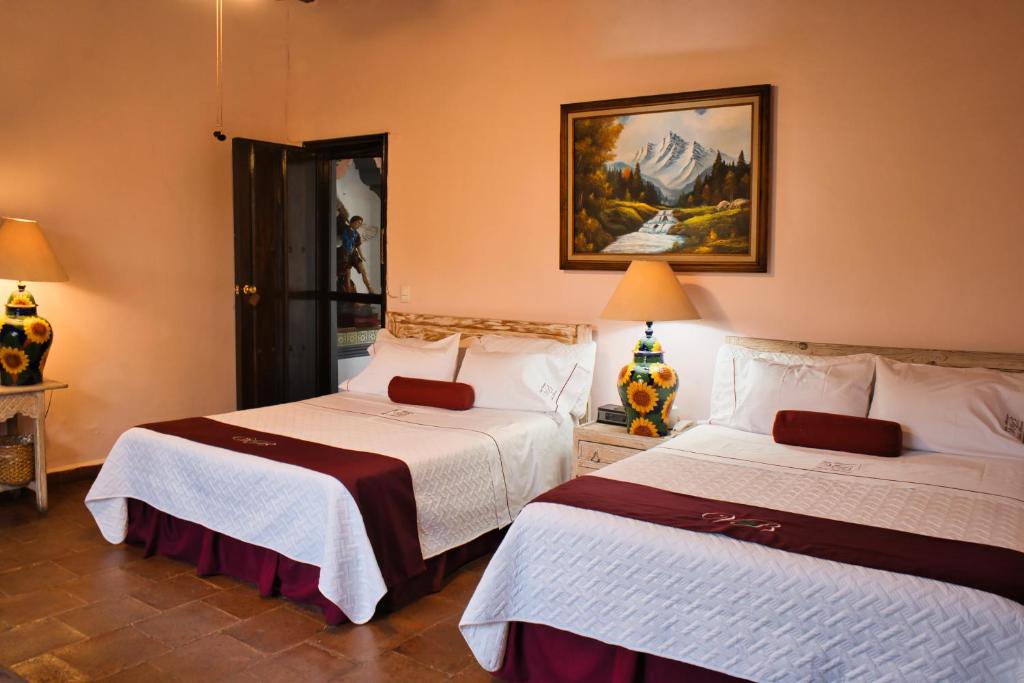 a bedroom with two beds and a painting on the wall at Villa Bonita Les Terrasses in Cuernavaca