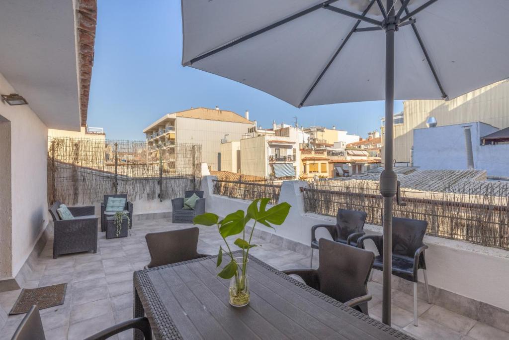 a patio with a table and chairs and an umbrella at Cambrils in Cambrils