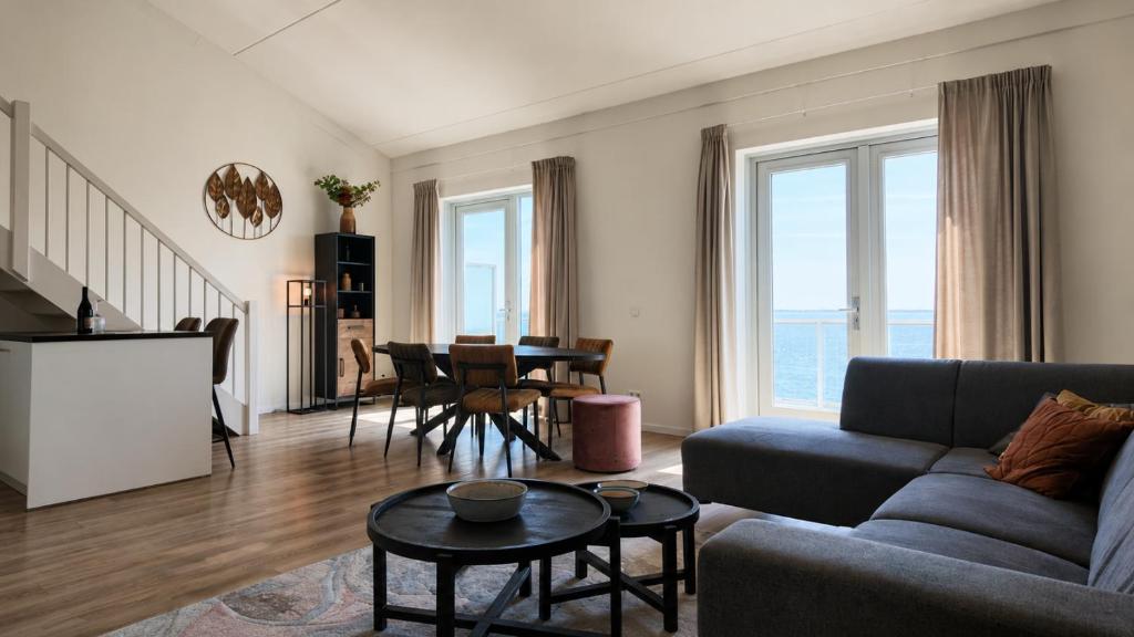 a living room with a couch and a table at Residentie De Zeester | De Schelp in Scherpenisse