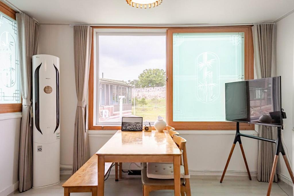 a kitchen with a table and a large window at Stay ongyeol in Suwon