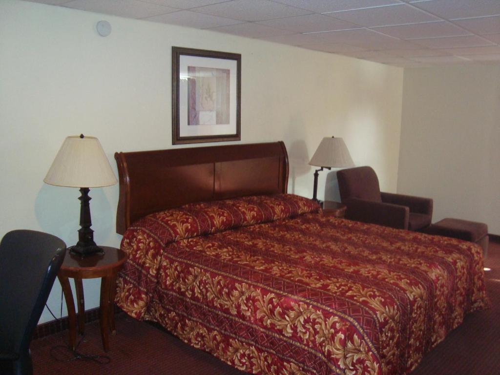 a hotel room with a bed and two chairs at Inn at Monticello in Monticello