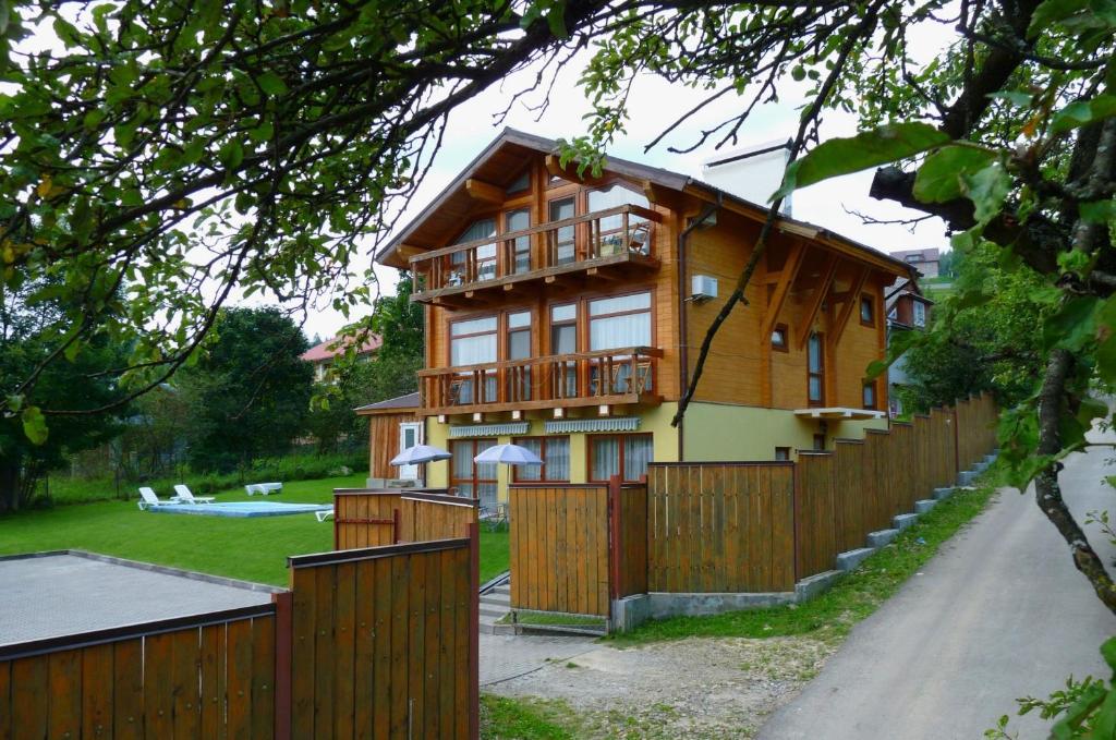 a house with a wooden fence and a yard at Chalet Mont Blanc in Yaremche