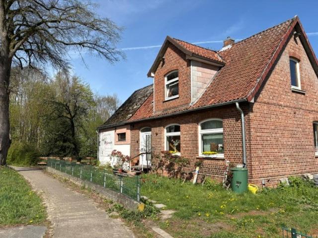 a brick house with a fence in front of it at Tischlerei in Barum