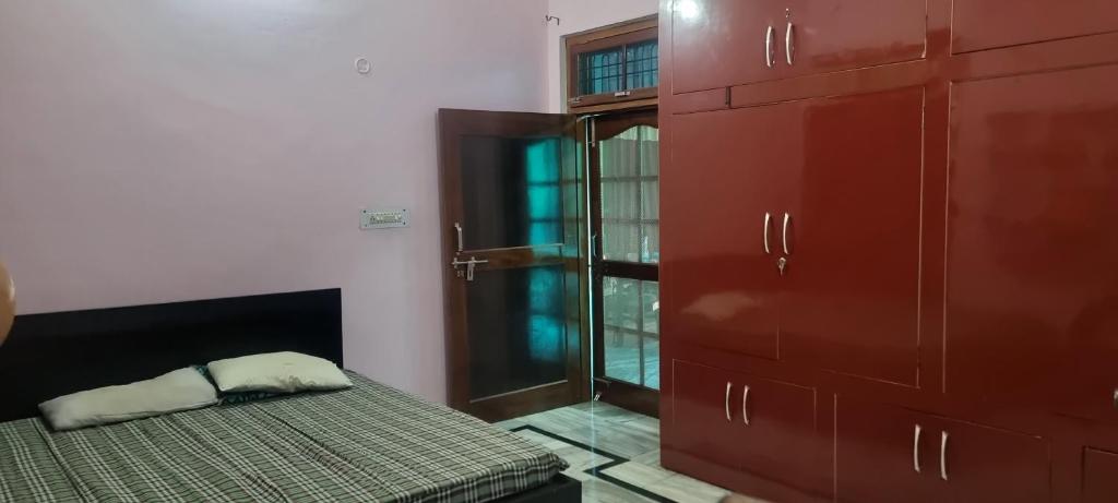 a bedroom with a bed and a closet and a window at Gyan Nivas in Bareilly