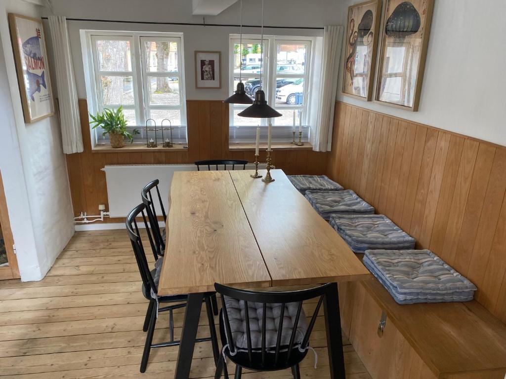 a dining room with a wooden table and chairs at Byhus Bogense in Bogense