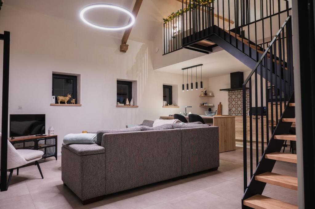 a living room with a couch and a staircase at De Viervoeters Hoeve in Ruiselede