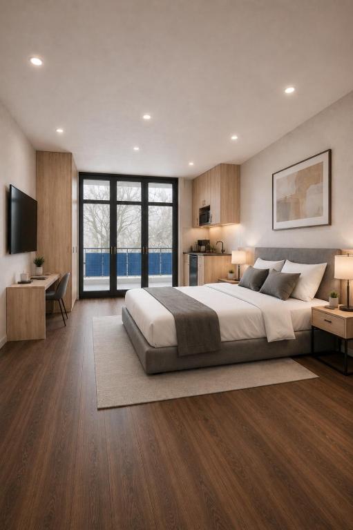 ein Schlafzimmer mit einem großen Bett und einem Fernseher in der Unterkunft HelloStay Zug Studios in Hünenberg