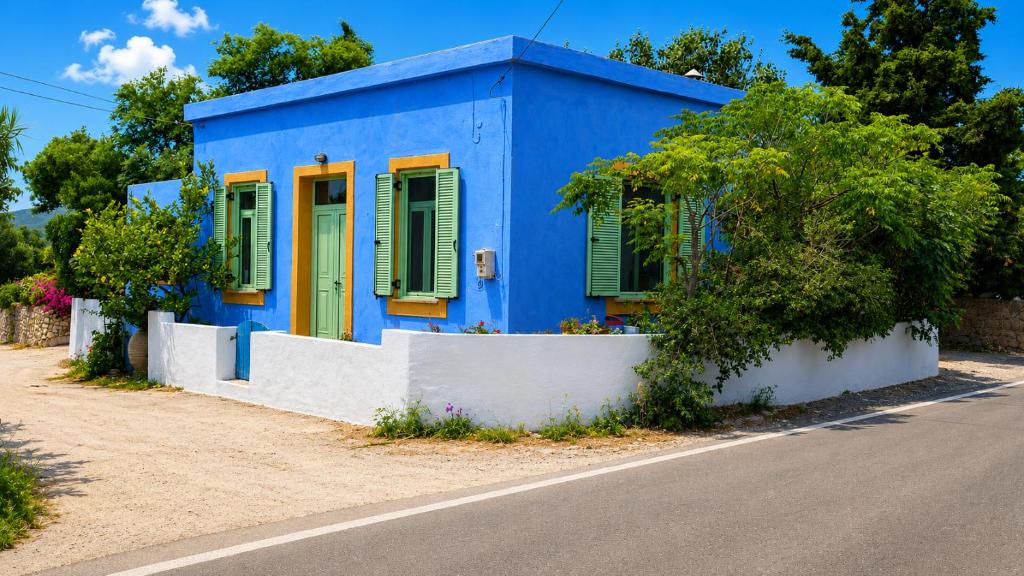 a blue house with green shutters on a street at The Blue - Kythira in Kondoliánika