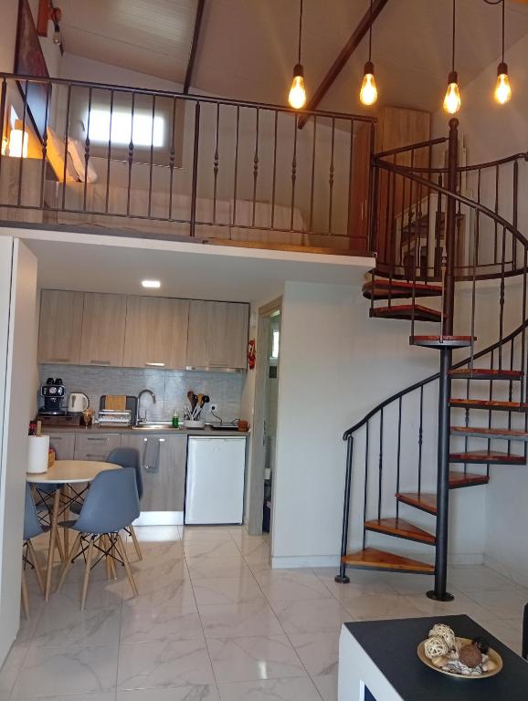 a kitchen and a living room with a spiral staircase at Studio Mare in Nea Kallikrateia