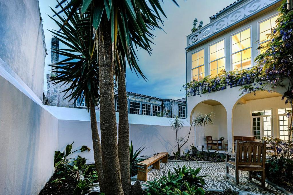 a house with a palm tree in a courtyard at GuestReady - Doctor House in Horta