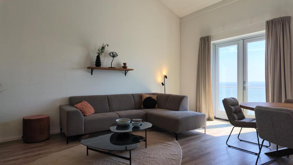a living room with a couch and a table at Residentie De Zeester | De Wulk in Scherpenisse