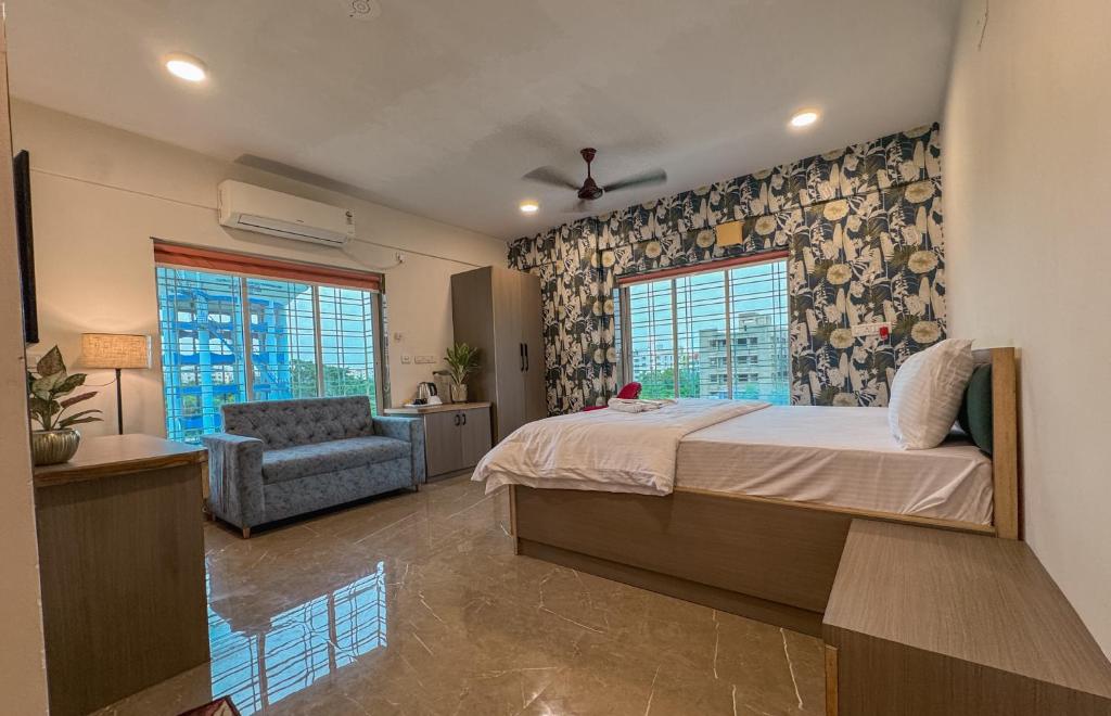 a bedroom with a bed and a chair and windows at The Botanika Suites in New Town