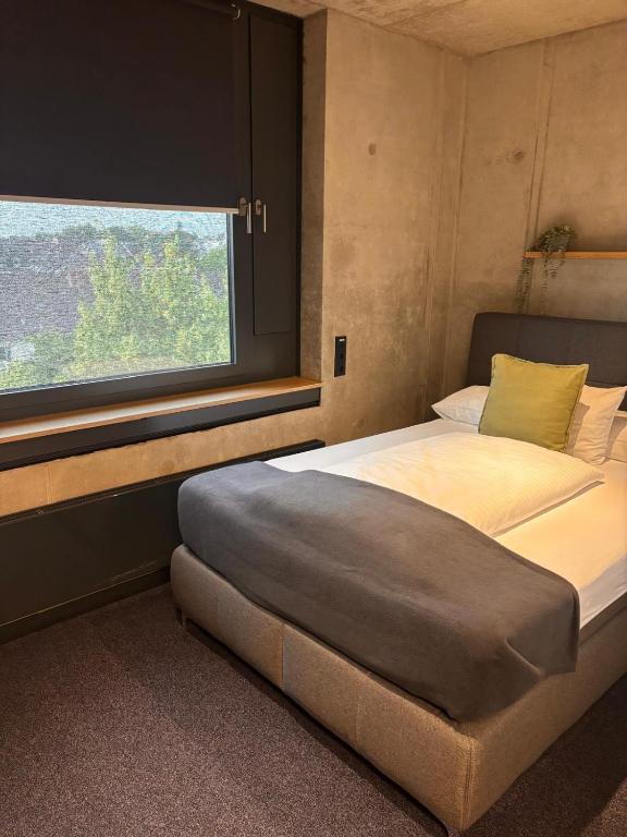 a bedroom with a large bed and a window at Hotel am Campus in Mönchengladbach