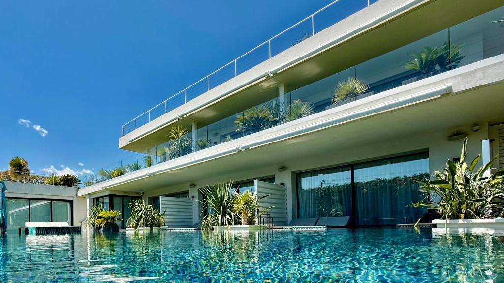 a building with a swimming pool in front of it at VILLA MIAMI in Les Issambres
