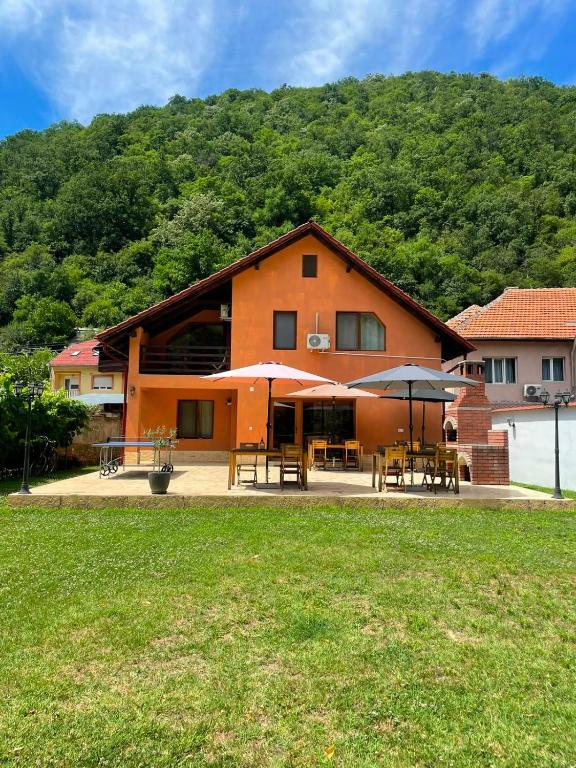 a building with tables and umbrellas in front of it at Casa Bianca in Băile Herculane