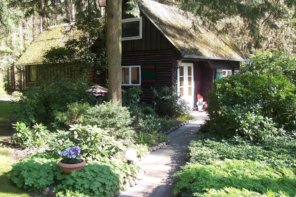 a log cabin with a flower pot in front of it at Feriendomizil Bockelmann in Bad Bevensen